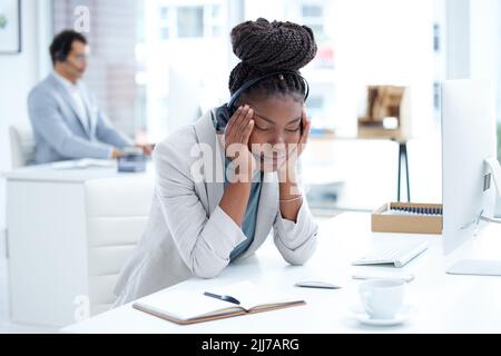 I messaggi istantanei sono molto in difficoltà oggi. Un giovane agente di call center che guarda stressato mentre lavora in ufficio. Foto Stock