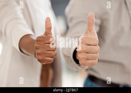 Non rinunciare mai a un sogno: Due agenti di call center irriconoscibili che mostrano i pollici in ufficio. Foto Stock