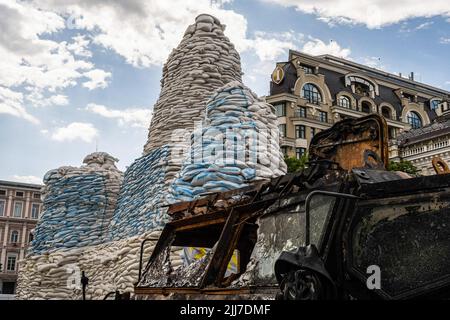 Kiev, Ucraina. 26th giugno 2022. Il Monumento alla Principessa Olga è coperto da sacchi di sabbia in Piazza Mykhailivska insieme al relitto di un veicolo militare russo a Kyiv. Capitale dell'Ucraina, Kyiv tiene una mostra di guerra "Guerra d'indipendenza Ucraina-2022" che mostra armi russe danneggiate e rimane per i cittadini come ricordo della guerra iniziata nel 2014 quando i separatisti russi annettero la Crimea, mentre la guerra continua a protrarsi nel paese, Quasi 5 mesi dopo l'invasione su vasta scala della Russia in Ucraina. Credit: SOPA Images Limited/Alamy Live News Foto Stock