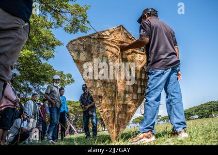 Raha, Indonesia. 23rd luglio 2022. Uno degli antichi proprietari di aquiloni prepara il suo aquilone. Il Kaghati Kolope, o aquilone antico, è il più antico aquilone del mondo, di 4 mila anni, basato su scoperte storiche trovate in una delle grotte dell'isola di Muna, Sulawesi sud-orientale. Tutte le parti costitutive di questo antico kite sono composte da materiali derivati dalla natura dove l'ingrediente principale è le foglie di kolope. (Foto di Andry Denisah/SOPA Images/Sipa USA) Credit: Sipa USA/Alamy Live News Foto Stock