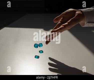 La donna lancia un paio di dadi trasparenti blu. Foto Stock
