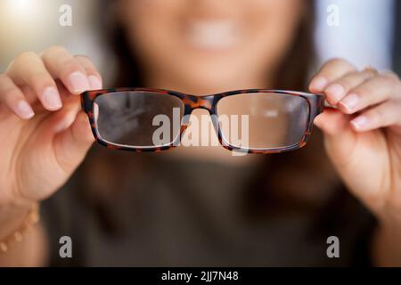 Itll mette a fuoco le cose. Una donna irriconoscibile che tiene un nuovo paio di occhiali al lavoro. Foto Stock