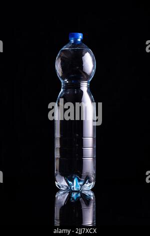 Bottiglia d'acqua in plastica su sfondo nero. Foto Stock