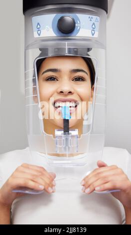 I raggi X sono una procedura standard presso il dentista. Una giovane donna che utilizza una macchina a raggi X in un ufficio dentistico. Foto Stock