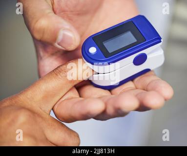 Come sono i livelli di ossigeno nel sangue. Un medico irriconoscibile che usa un ossimetro su un paziente. Foto Stock