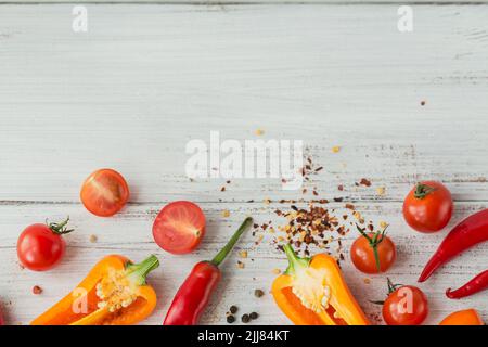 Mix di peperoni caldi e colorati freschi, pomodori ciliegini e spezie sul tavolo bianco mock up Foto Stock