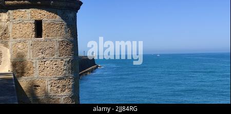 Vista sul mare e il cielo blu sulla costa di Cadice e una storica scatola di sentry box. Foto Stock