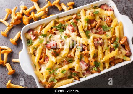 Casseruola fatta in casa con pasta, funghi, pancetta e formaggio serviti caldi dal forno sul tavolo. Vista dall'alto orizzontale Foto Stock