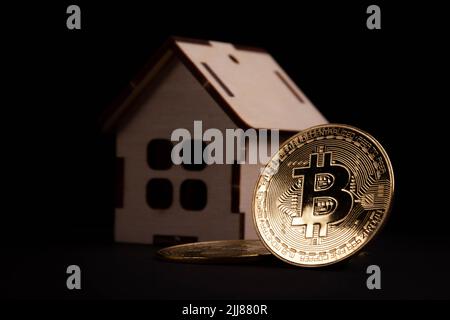 Acquisto di immobili per criptovaluta. Pagare per l'alloggio con bitcoins. Bitcoins come mezzo di pagamento. Moneta e casa. Foto Stock