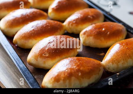 Piroski di carne russa. Mini torte tradizionali a mano su sfondo di legno. Stile rustico, vista da primo piano. Le polpette tradizionali russe di solito fatte dal nonno Foto Stock