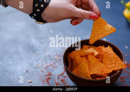 spazzatura fast food mangiare nacho chips mano tenere fresco Foto Stock