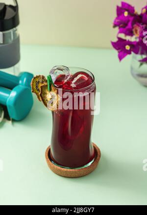 Rinfrescante bevanda salutare in una lunga tazza di vetro su sfondo verde chiaro Foto Stock