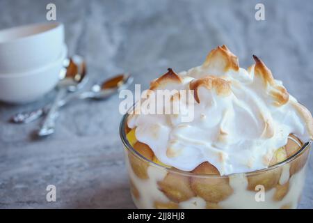 Budino di banane fatto in casa fresco fatto da zero per le vacanze dall'alto. Stratificato con wafer e meringa. Messa a fuoco selettiva. Foto Stock