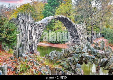 Incredibile paesaggio autunnale in Azalea e Rhododendron Park Kromlau. Rakotz Bridge (Rakotzbrucke, Ponte del Diavolo) Ubicazione: Gabbenz, stato della Sassonia Foto Stock