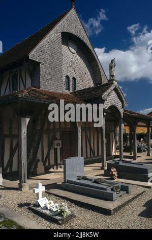 Una statua in pietra dell'apostolo San Giacomo il Grande si trova all'apice del portico ovest in legno rivestito di piastrelle e ardesia dell'église Saint-Jacques-et-Saint-Philippe a Lentilles, nel Pays du Der dell'Aube a Grand Est, Francia. La chiesa, fondata intorno al 1512, è un tipico esempio delle storiche chiese a graticcio o a graticcio della regione dello Champagne, con massicce travi di quercia che sorreggono i tetti di tegole rosse. Le scandole di legno sono ricoperte anche dal timpano occidentale e da un campanile ottagonale. Foto Stock