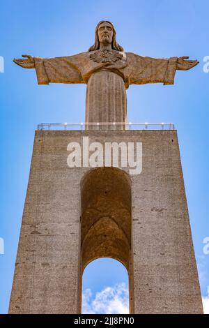 Cristo Re raffigurato nella statua di Cristo Redentore ad Almada contro il cielo blu, Lisbona, Portogallo Foto Stock