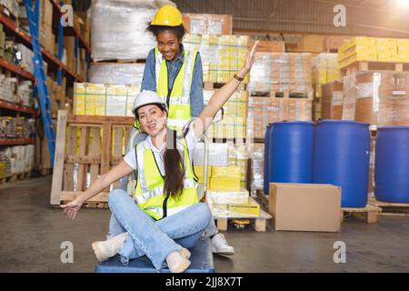 Le donne lavoratrici del magazzino godono di lavoro di squadra con amici sorriso felice sul posto di lavoro. Foto Stock