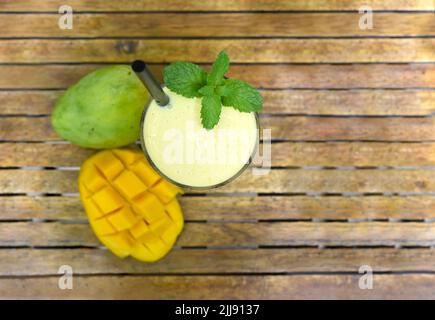 Mango lassi con mango fresco a fette su tavola di legno Foto Stock