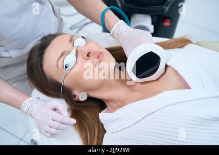 Donna in centro di cosmetologia subisce una procedura di ringiovanimento della pelle del collo Foto Stock