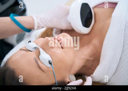 Donna in centro di cosmetologia subisce una procedura di ringiovanimento della pelle della nuca Foto Stock