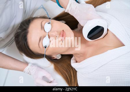 Il paziente viene sottoposto a una procedura per ringiovanire la pelle della decolletta Foto Stock