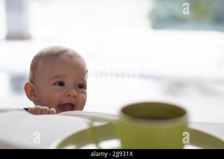 Ridendo toddler mischievous con un'espressione naughty carina, il capriccioso piccolo ragazzo biondo disturbemaker, vita domestica quotidiana spazio di copia della scena di infanzia Foto Stock