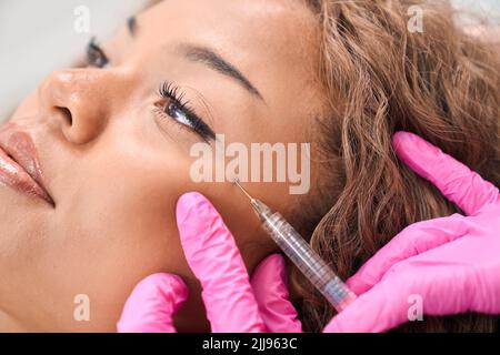 Lady riceve iniezioni di tossina botulinica in una clinica di cosmetologia Foto Stock