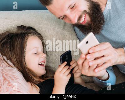 felice famiglia tempo libero papà bambino ridere insieme telefono Foto Stock