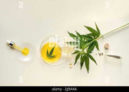 Olio CBD in una pipetta, tintura, semi di canapa e foglie di marijuana su sfondo chiaro Foto Stock