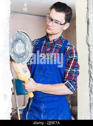 Maschio con smerigliatrice angolare professionale Foto Stock