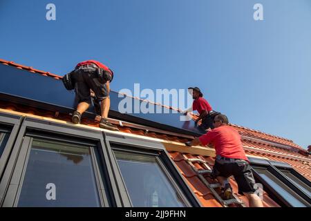 Installazione di pannelli solari per energia solare termica. La società Hanschke Solarmontagen installa pannelli solari su un edificio di appartamenti di nuova costruzione Foto Stock