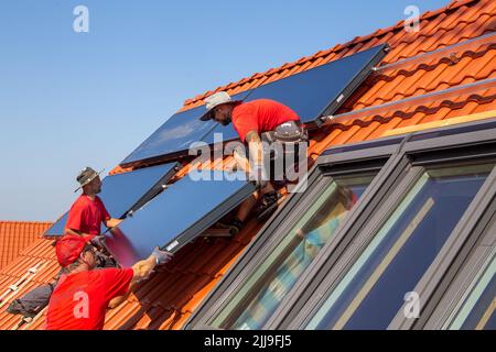 Installazione di pannelli solari per energia solare termica. La società Hanschke Solarmontagen installa pannelli solari su un edificio di appartamenti di nuova costruzione Foto Stock