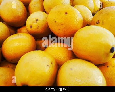 Raccolto di arance. Molte arance. Arance dal campo. Sfondo arancione. Un sacco di malta fresca sul mercato Foto Stock