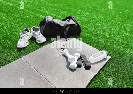 Articoli sportivi, orologi sportivi e sneaker da running su sfondo grigio, set di oggetti per esercizi all'aperto, stile di vita sano e concetto di cura del corpo Foto Stock