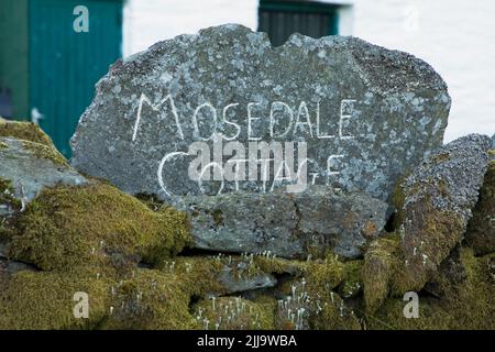 La targhetta fuori Mosedale Cottage, Mosedale, nel Lake District inglese Foto Stock