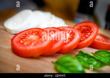 Pomodori sulla vite - Solanum lycopersicum - pomodoro rosso basilico mozzarella insalata - mozzarella - stile di vita vegetariano e cibo da cucina - pomodori maturi Foto Stock