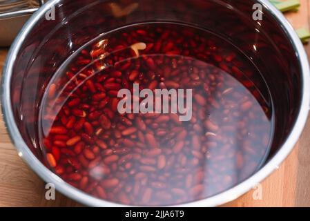 fagioli rossi immersi in acqua prima della cottura. legumi sani, fagioli renali. Foto Stock