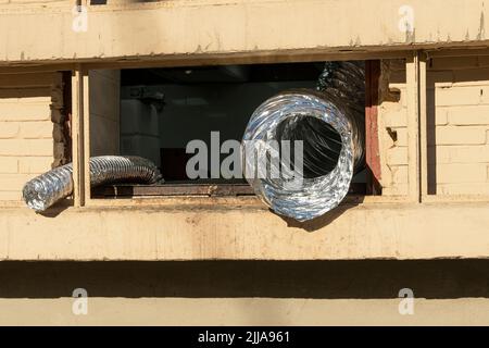 Tubo flessibile in alluminio alla finestra. Tubo flessibile di scarico corrugato Foto Stock