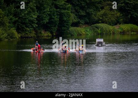 Tre Dragon Boats che corrono lungo il fiume Mersey nella competizione finale della giornata con la barca di sicurezza alle loro spalle Foto Stock