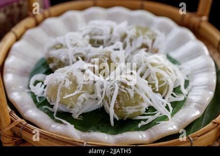 Palline di cocco thailandesi, Kha Nom Tom, su piatto bianco e cestino di rattan. Foto Stock