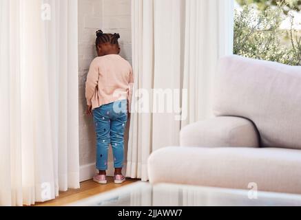 Shes è stato inviato al timeout. Una bambina in piedi in un angolo come una punizione a casa. Foto Stock