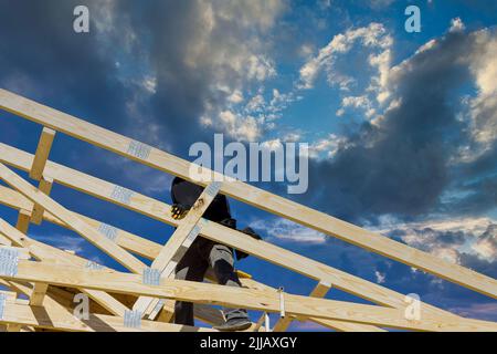 Tetto che lavora con l'incorniciatura installazione del tetto travature legno di operai che chiodano travi di legno Foto Stock