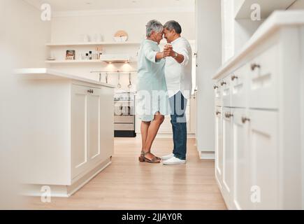 Ho detto fino a quando erano vecchi e grigi... una coppia matura che ballava in cucina a casa. Foto Stock