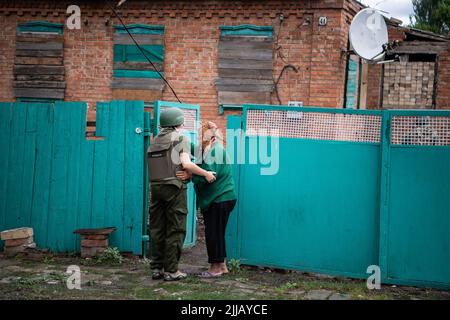 Siverk, Ucraina, 23/07/2022, Un volontario tenta senza successo di convincere una donna anziana ad evacuare dalla città di Sivers'k. I volontari distribuiscono aiuti ai residenti locali e forniscono evacuazioni in sicurezza nella città di Sivers'k, che è stata sottoposta a pesanti bombardamenti sui fronti orientali della guerra Russia-Ucraina. Credit: SOPA Images Limited/Alamy Live News Foto Stock