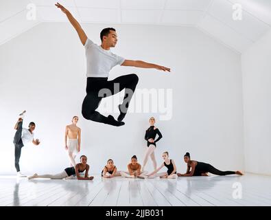 Ballare è la sua passione. Sparato a tutta lunghezza di un gruppo diversificato di studenti di balletto che provano nel loro studio di danza. Foto Stock