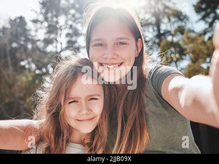 Mi piace essere una sorella grande, una ragazza che prende un selfie con la sorella più giovane. Foto Stock