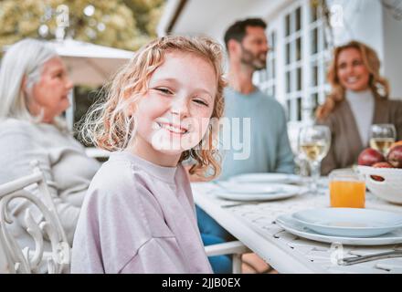 Le famiglie sono come la fudge per lo più dolce, con qualche noce. Una bambina seduta ad un tablet con la sua famiglia a casa. Foto Stock