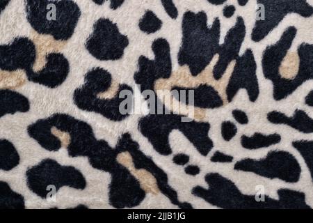 Motivo pelle leopardo su una coperta con colori bianco e nero, tema safari. Punto di vista campione con campitura di tessuto modellata direttamente dall'alto. Foto Stock