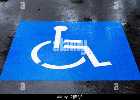 Un simbolo di parcheggio per disabili (sedia a rotelle) dipinto su uno spazio auto piovoso alla Stazione ferroviaria di Como a Sydney, nuovo Galles del Sud, Australia Foto Stock