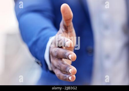 Un uomo d'affari irriconoscibile che si allunga la mano per una stretta di mano sul lavoro. Foto Stock